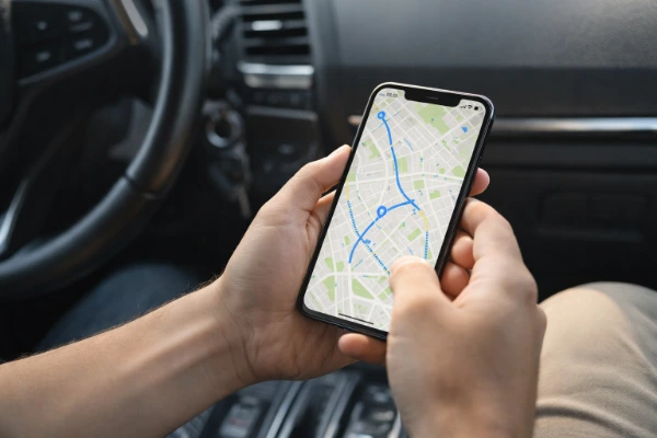 seguro automático via GPS em 2026 com motorista acompanhando localização do veículo em tempo real pelo celular dentro do carro