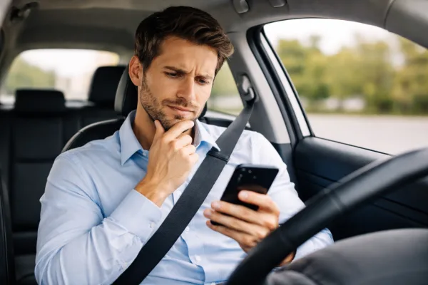 Motorista comparando preços de seguro auto barato em 2026 no celular