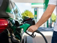 Carro gastando muito combustível sendo abastecido em um posto, ilustrando os erros que aumentam o consumo do veículo.